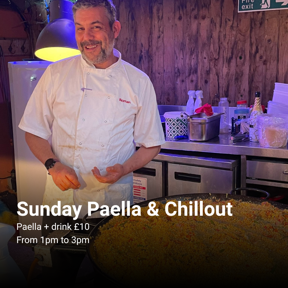 Chef smiling to the camera with a paella